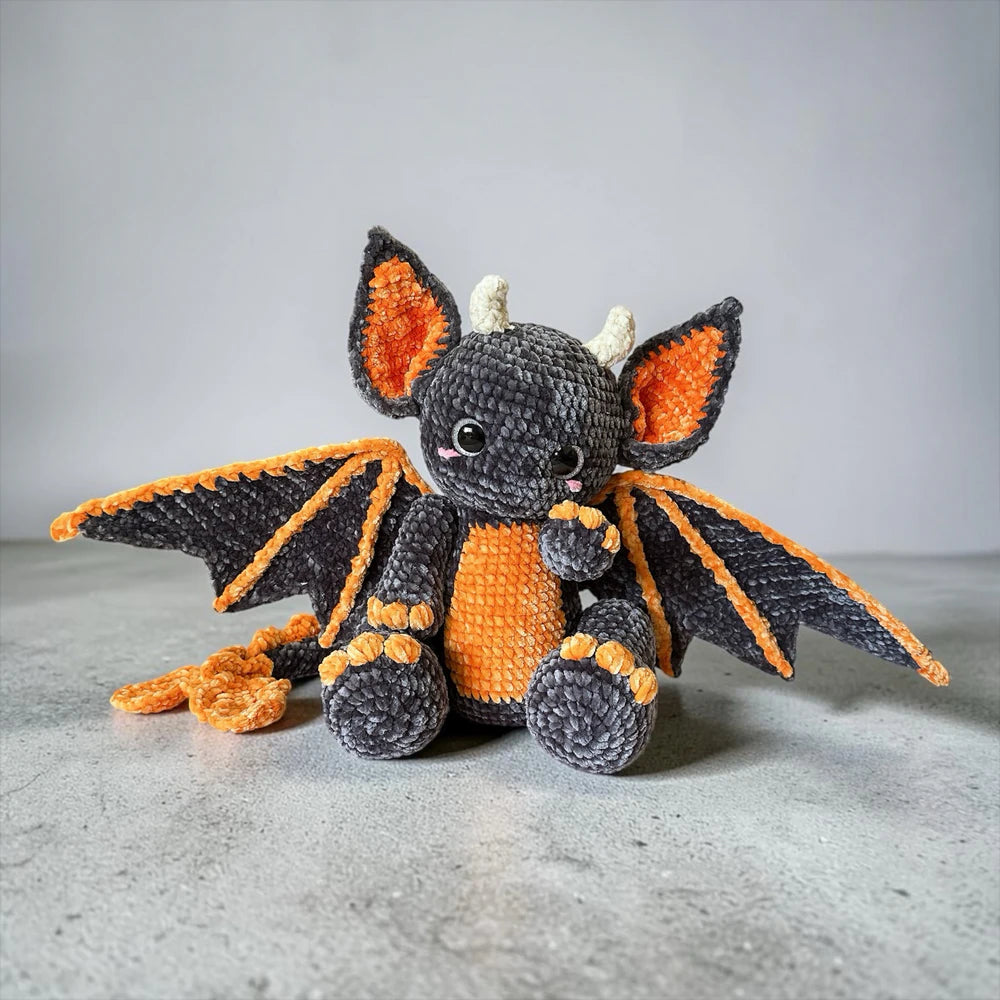 Bat Dragon Crochet Pattern finished spooky cute amigurumi plushie with oversized bat ears, wings, horns, and orange Halloween details