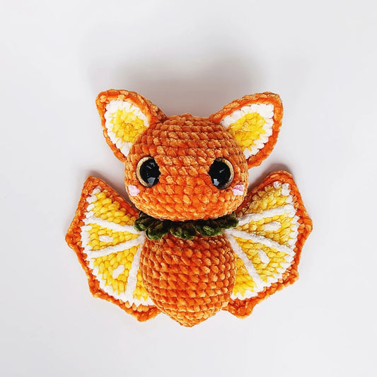 Orange Bat Crochet Pattern featuring orange-slice wings, big bat ears and a leafy green collar