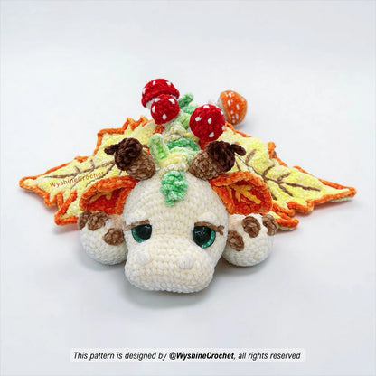 Large dragon crochet pattern with maple leaf wings, grassy back spikes, mushrooms, and cozy fall decor details
