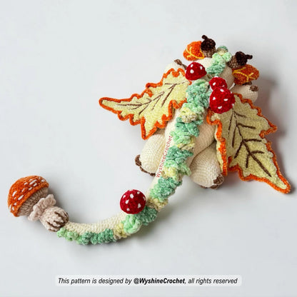 Autumn crochet pattern dragon plushie with long curled tail, mushroom tail tip, and woodland fantasy amigurumi design
