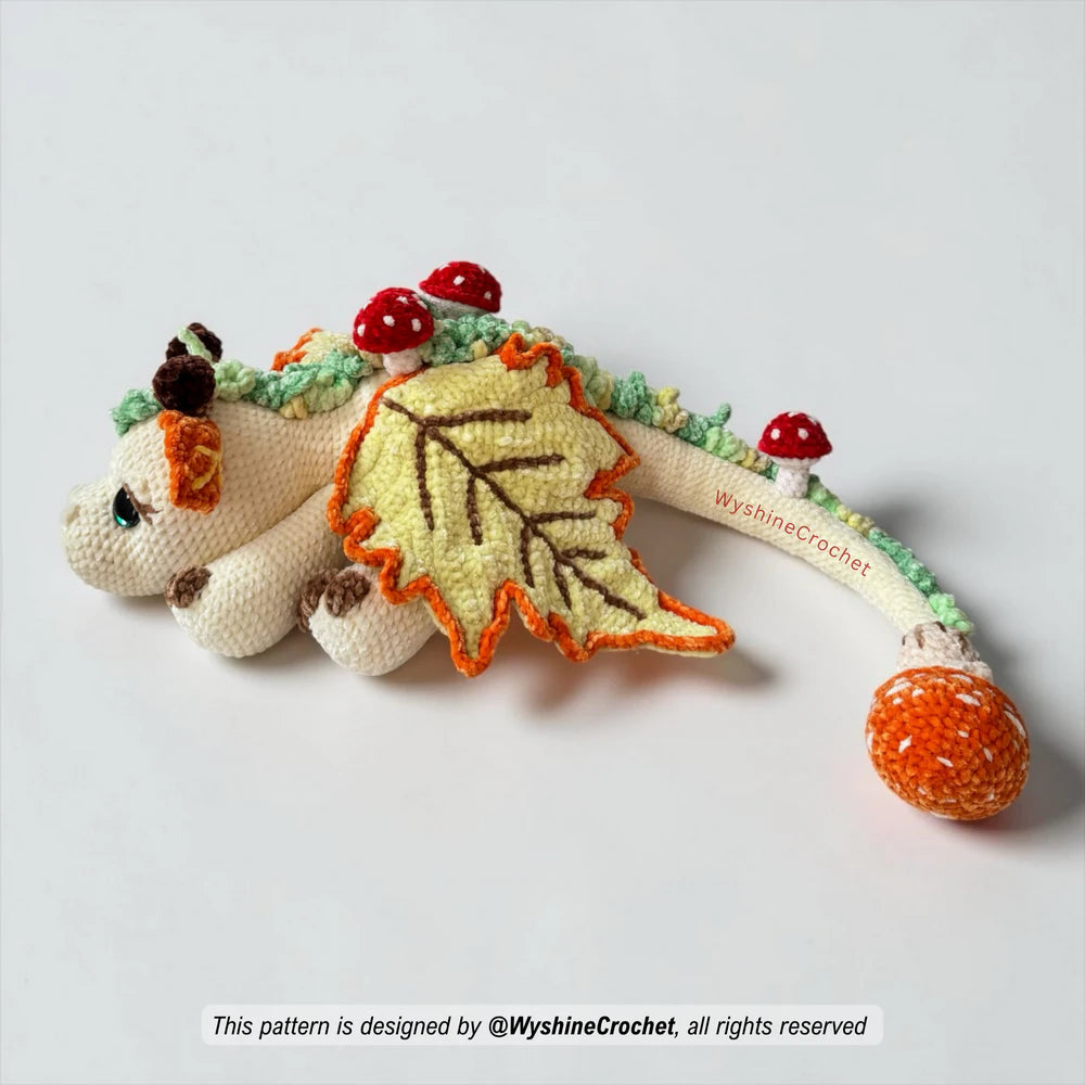 Materials for Fall Dragon crochet pattern including chenille yarn, 30 mm safety eyes, 5 mm hook, and fiberfill
