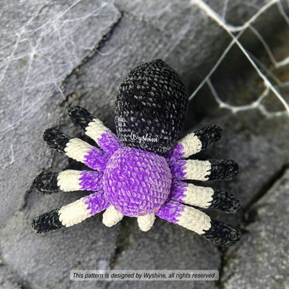 Crocheted spider toy with black, white, and purple colors on a textured surface.
Realistic Spider Amigurumi with Web Crochet Pattern - Halloween & Fall Decoration