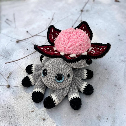  Brain Flower Spider Crochet Pattern finished Halloween amigurumi plushie with pink brain flower, dark red petals, gray spider body, and eight legs
