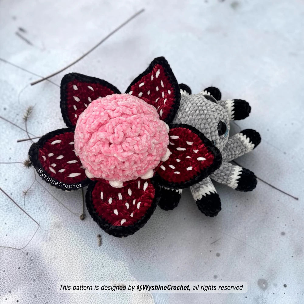 Spooky cute spider crochet pattern PDF featuring a brain-shaped flower, layered petals, tiny teeth, and soft chenille amigurumi texture
