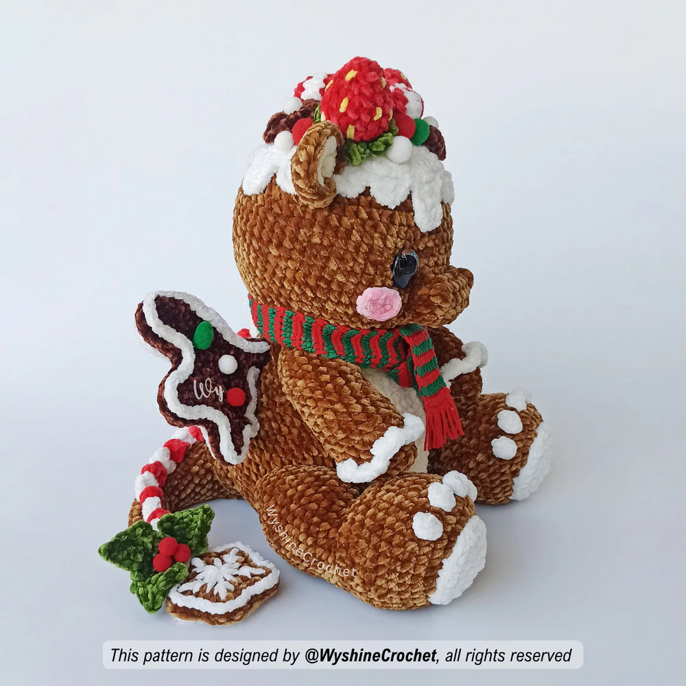 Gingerbread Dragon crochet plushie featuring a rounded brown body, cream belly, red and white decorations, and Christmas scarf