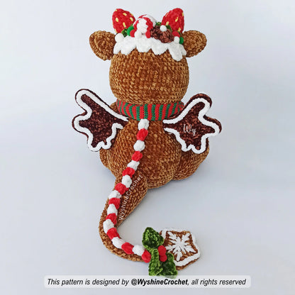 Chubby Gingerbread Dragon Crochet Pattern showing a star-cookie tail ornament, snowflake embroidery, holly leaves, and festive holiday details