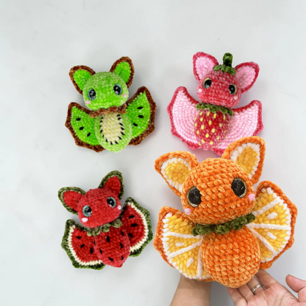 Four colorful Fruit Bat amigurumi characters displayed together for cozy fall and Halloween decor
