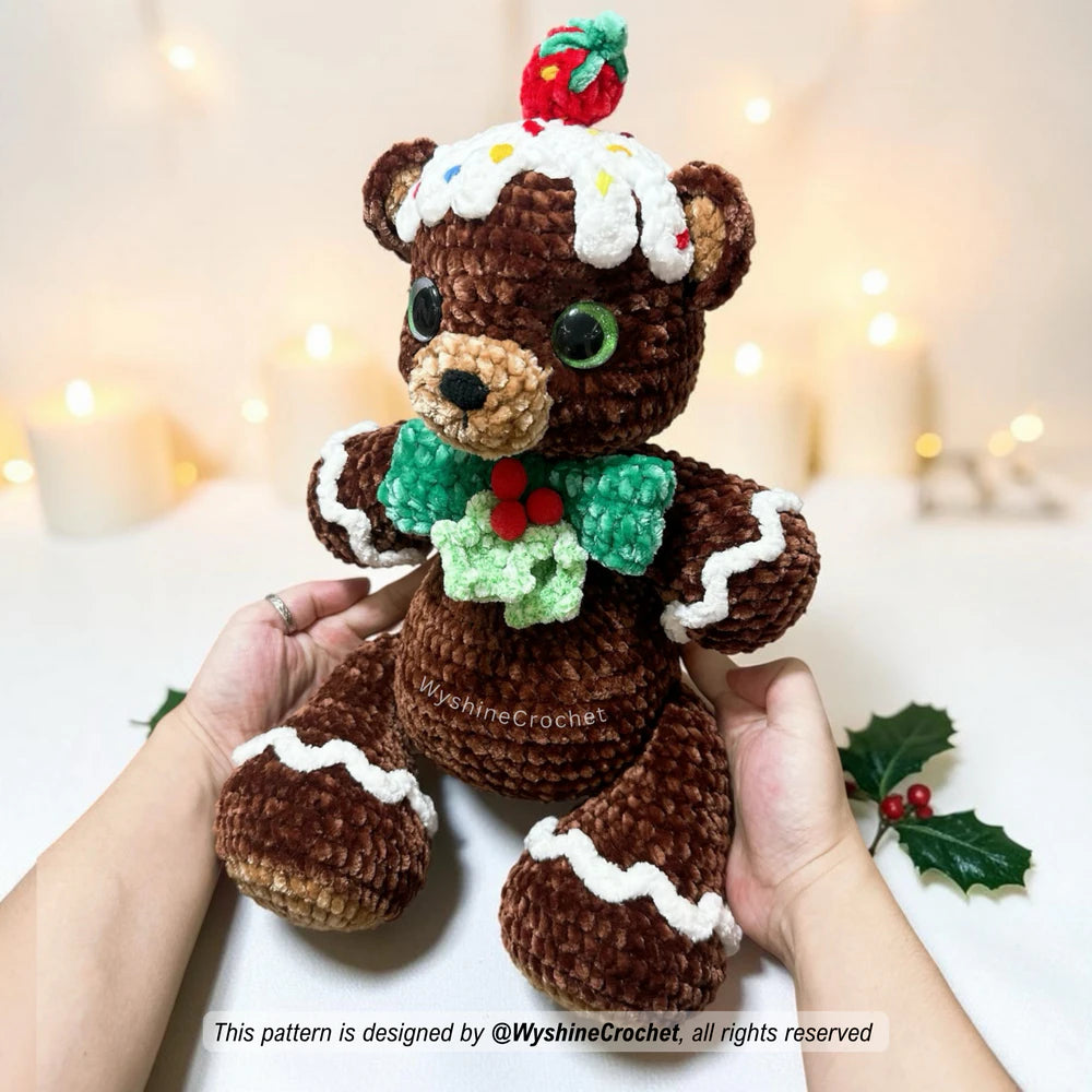 Close-up of Gingerbread Bear crochet pattern details with safety eyes, embroidered face, frosting, and berry accents
