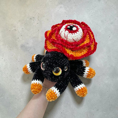 Rose Eye Spider Crochet Pattern finished Halloween amigurumi plushie with red rose petals, large central eye, black spider body, and spooky fall style
