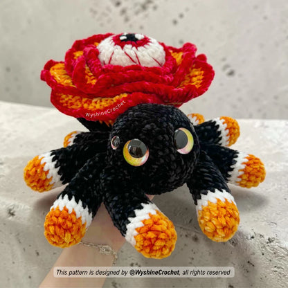 Halloween spider crochet pattern with rose flower body, spooky eye detail, black legs, orange and white foot accents, and fall decor style
