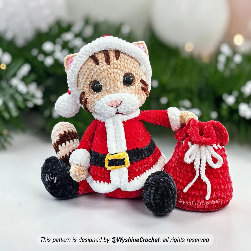 Cute Santa Cat amigurumi wearing a red Christmas hat with white trim, pink cat ears, and soft chenille yarn texture